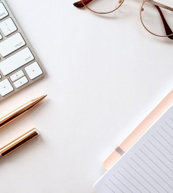pen near black lined paper and eyeglasses